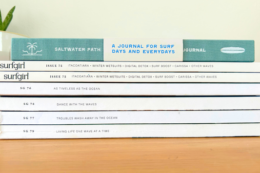 Stack of SurfGirl magazines with the Saltwater Path Surf journal